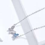 925 Silber Collier-Halskette mit zwei zarten Schmetterlingen, einer mit blauen Zirkonia-Kristallen besetzt, filigrane Detailarbeit sichtbar.