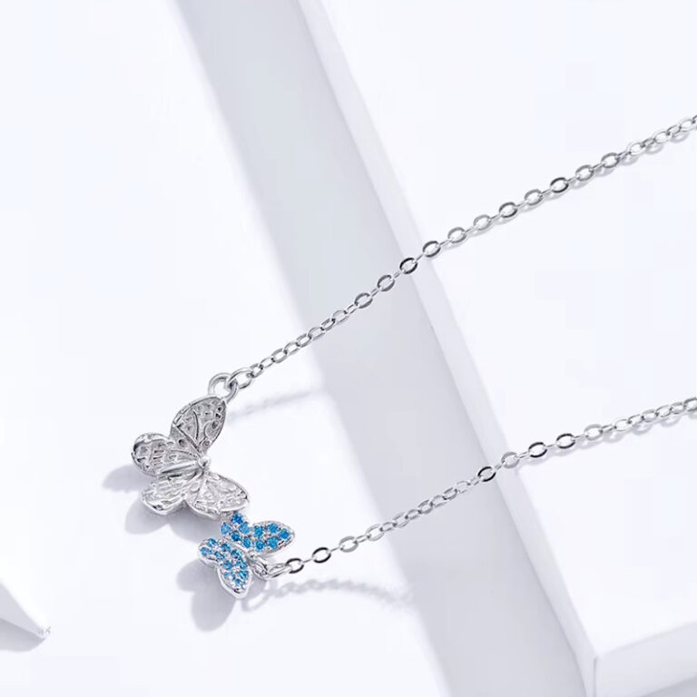 925 Silber Collier-Halskette mit zwei zarten Schmetterlingen, einer mit blauen Zirkonia-Kristallen besetzt, filigrane Detailarbeit sichtbar.