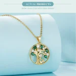 Goldener Lebensbaum Anhänger mit grünen Kristallen und Zirkonia, 925 Silber Halskette. Detail: Mensch Figur unter Baum. Schmuck Produktaufnahme.