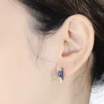 Blauer Tulpen Ohrring aus 925 Silber mit Zirkonia im Russischen Schloss. Blumen Huggies Ohrstecker Detailaufnahme am Ohr.