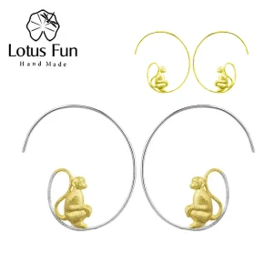 Spiral Creolen mit goldenem Affen. Teilvergoldete, mattierte Ohrhänger aus 925 Silber. Detail: Affe sitzt auf filigranem Spiral-Design.