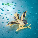 Goldene Vogel-Brosche aus 925er Silber mit blau-weißem Zirkonia-Pavé. Die filigrane Anstecknadel zeigt einen Blaumeise- oder Blauhäher-Vogel auf einem Ast. Der Schmuck ist vergoldet und mit einem Spinell-Auge versehen.