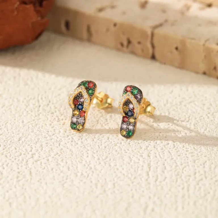 Goldene Flip-Flop Ohrstecker mit bunten Zirkonia-Steinen. Die 925 Silber Ohrringe sind vergoldet und im 3D-Design einer Miniatur-Sandale gefertigt. Sommerlicher Schmuck mit farbigem Pavé.